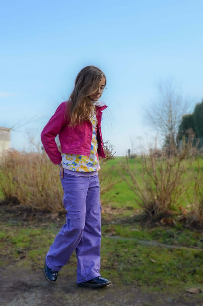 Enfant portant le Pantalon BAGGY ALVIDA violet, à la mode, avec coupe large et poches, patron de couture pdf à télécharger.