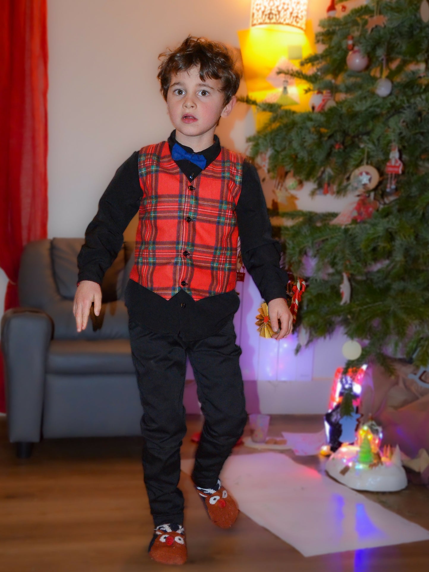 Enfant portant un Pantalon Enfant EBENE près d'un sapin de Noël, idéal pour occasions décontractées et cérémonies, patron de couture pdf à télécharger.