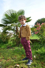 Enfant portant Pantalon Enfant EBENE tendance avec touches contrastées, parfait pour tenues décontractées ou cérémonies. Patron de couture pdf à télécharger.