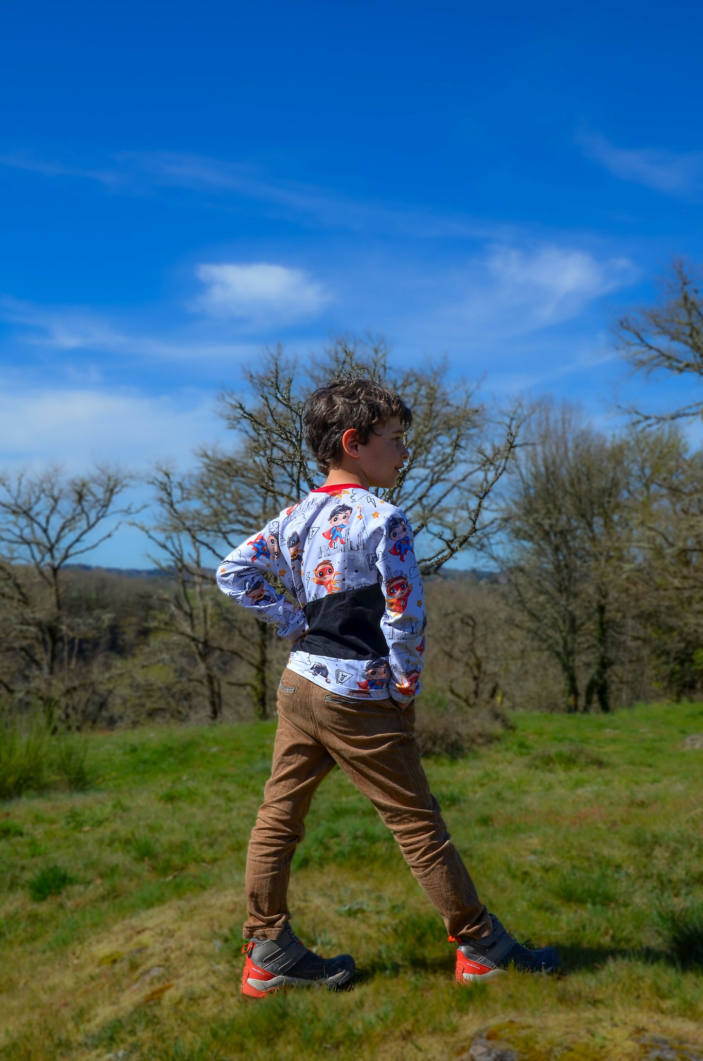 Enfant portant le Pantalon Enfant EBENE avec touches contrastées, dans un cadre décontracté, idéal pour les cérémonies. Patron de couture pdf à télécharger.