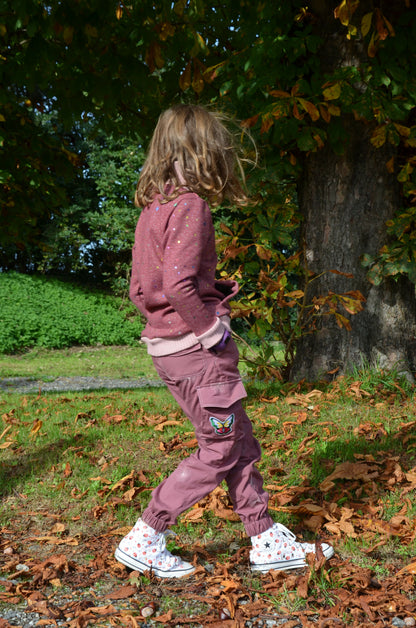 Enfant portant le Pantalon Enfant LAST rose, en promenade, avec patron de couture pdf à télécharger, style cargo tendance.