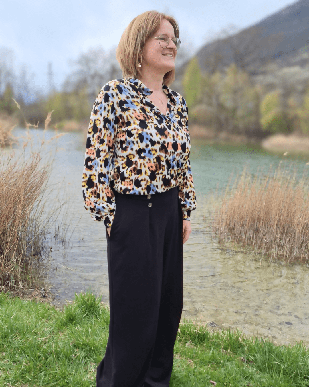 Femme portant le Pantalon Pym’s - Patron PDF Femme du 32 au 52, modèle ample en jersey extensible, près d'un lac. Patron de couture pdf à télécharger.