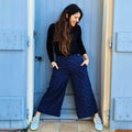 Femme portant le Pantalon - Short Deauville - T34 à 48, patron de couture pdf à télécharger, élégante et moderne devant une porte bleue.