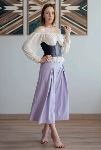 Femme portant un pantalon - XXS-XL - VINTAGE CADILAC avec une blouse élégante, accessoires modernes.