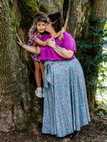 Femme et enfant portant le Patron PDF AMARENA, robe et blouse assortie en viscose à motif floral, entre deux arbres mousses