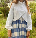 Femme portant le Patron PDF Gilet Tourmaline, vue de face avec chemise à carreaux bleu et blanc sous gilet blanc ouvert