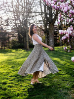 Femme portant la jupe Patron PDF Jupe NOISETTE Femme/Enfant virevoltant dans un jardin, élégance et fluidité, patron de couture pdf à télécharger