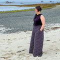 Femme portant Patron PDF Jupe-culotte Aneth, silhouette large et fluide en coton, sur plage rocheuse avec vue sur mer