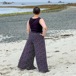 Femme portant le Patron PDF Jupe-culotte Aneth du 34 au 56, vue de dos à la plage, coupe large et fluide