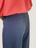 Femme portant le Patron PDF Pantalon Elio du XS au XXL, vue de profil en sergé bleu marine avec plis marqués