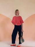 Patron PDF Pantalon Elio Femme XS-XXL, vue de face en sergé marine, coupe droite, porté avec top rouge corail