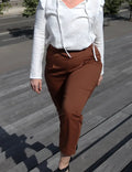 Femme portant le Patron PDF Pantalon Jasmin en sergé marron, vue de côté en situation urbaine