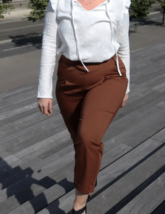 Femme portant le Patron PDF Pantalon Jasmin en sergé marron, vue de côté en situation urbaine