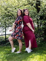 Deux femmes portant le Patron PDF Polo multi-manches Kiwi, dehors dans un jardin verdoyant, vue de dos souriantes