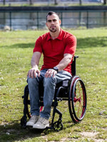 Homme portant le Patron PDF Polo multi-manches Kiwi en coton rouge, assis en extérieur