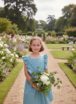 Fillette portant le Patron PDF Robe Angélico du 2 au 14 ans, manches courtes à volants, allée fleurie de jardin