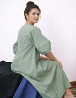 Femme portant le Patron PDF Robe longue IRIS, manches courtes en lin, assise de profil, vue n°6