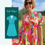 Femme portant le Patron PDF Robe Pelagia, motifs géométriques colorés, manches courtes, devant campagne verdoyante