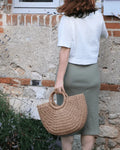 Femme portant le Patron PDF Robe et Top Cotelle, jupe midi en coton, vue de dos contre un mur en pierre