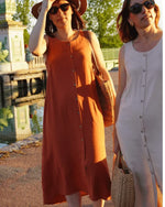 Patron PDF Robe Aliz du 32 au 52, robe portefeuille en lin orange, vue portée en extérieur près d'une rivière