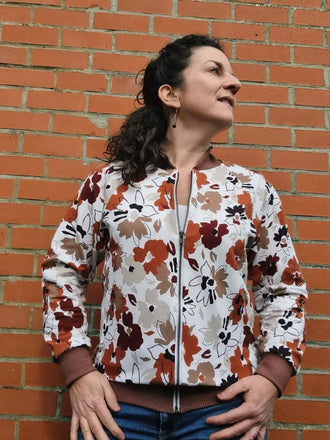Femme portant le Patron PDF Sweat ALPIN Adulte du XXS au 6XL, modèle floral, devant un mur de briques, patron de couture pdf à télécharger.