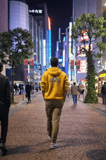 Homme portant le Patron PDF Sweat ATLAS Adulte du XXS au 6XL dans une rue illuminée de la ville, patron de couture pdf à télécharger