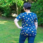 Femme portant le Patron PDF T-Shirt Femme manches courtes Pomélo du 34 au 56 dans un jardin, patron de couture pdf à télécharger.