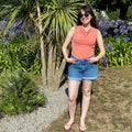 Femme portant le Patron PDF T-Shirt col bénitier sans manche Mandarine, debout dans un jardin fleuri
