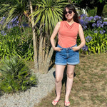 Femme portant le Patron PDF T-Shirt col bénitier sans manche Mandarine, debout dans un jardin fleuri