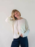 Femme portant le Patron PDF Top Luca du XS au XXL, col rond manches longues en coton blanc cassé, vue de face souriante