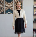 Patron PDF Veste Regina du XS au XL, vue de face, veste courte écrue sur robe noire avec franges