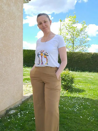 Femme portant le Patron PDF Pantalon A du 32 au 60, coupe large en camel, debout dans un jardin