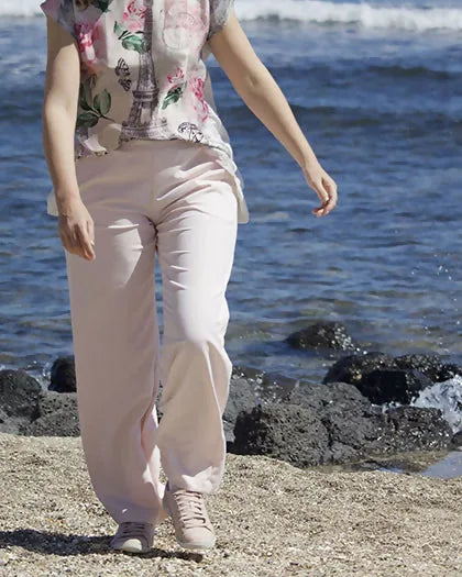 Femme portant le Patron PDF Pantalon A du 32 au 60, en lin blanc, marchant sur la plage