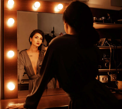 Femme portant un Peignoir - XS/XL - CLASSY DITA se maquillant devant un miroir éclairé, patron de couture pdf à télécharger.