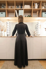 Femme portant un Peignoir du XS au XL - ELOGIUM, avec patron de couture pdf à télécharger, admirant un intérieur moderne.