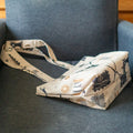 Petit Tote Bag avec Fond en coton écru, motifs marins bleu et beige, posé sur canapé gris