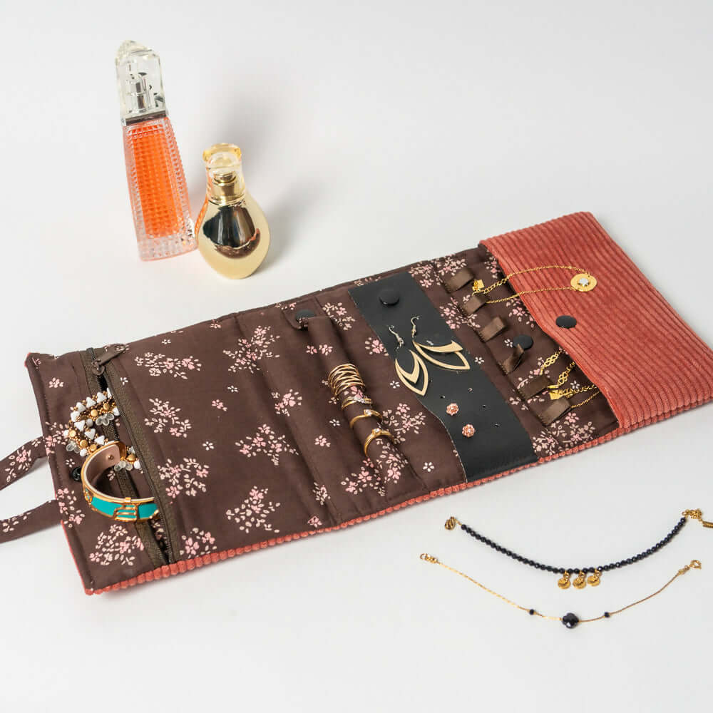 Pochette à bijoux Violette ouverte, avec bijoux rangés, parfums en arrière-plan, pour filles et femmes.