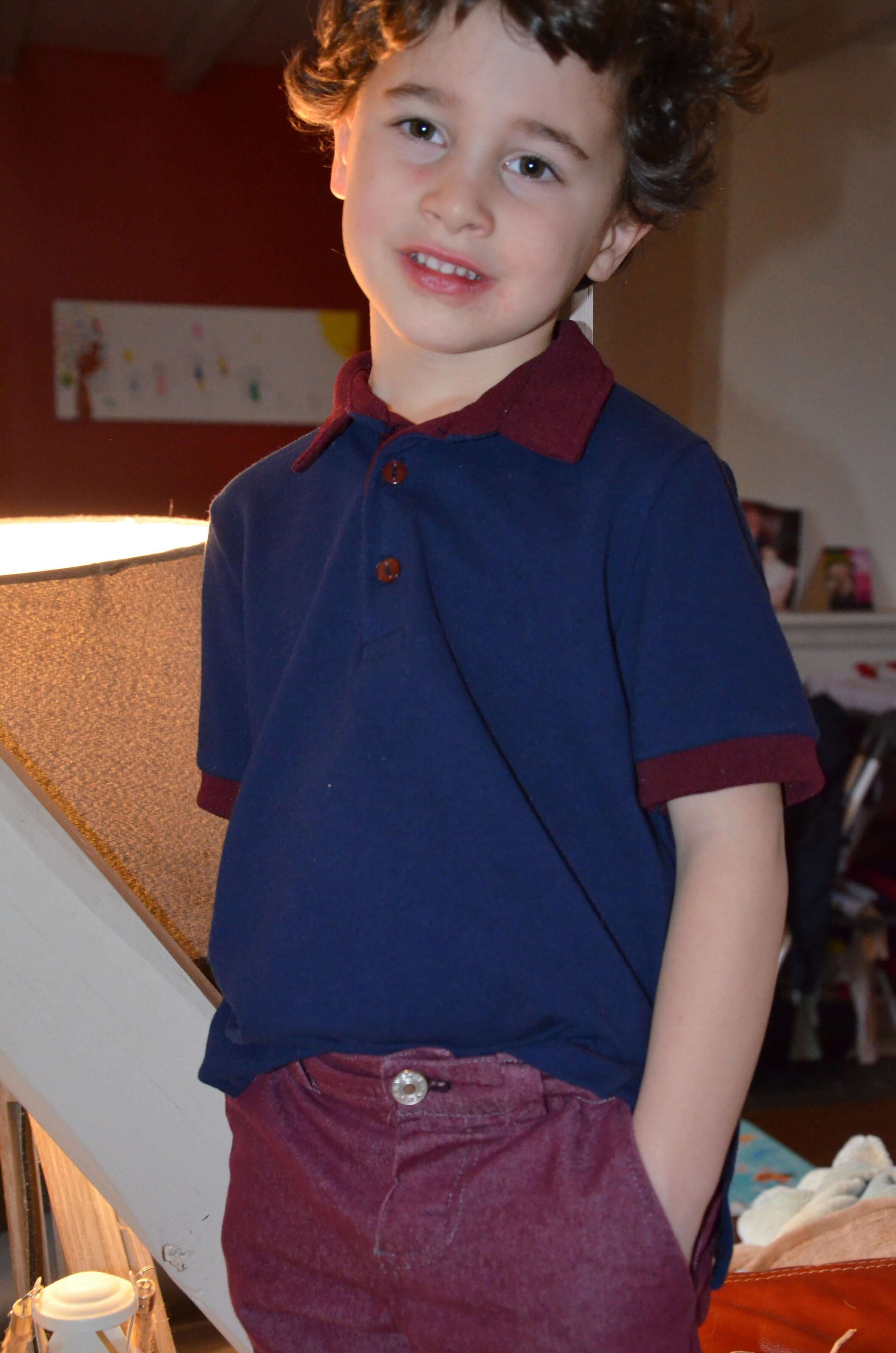 Enfant portant un Polo MARCOLOPO bleu à manches courtes, patron de couture pdf à télécharger, avec col bord côte et ourlet.