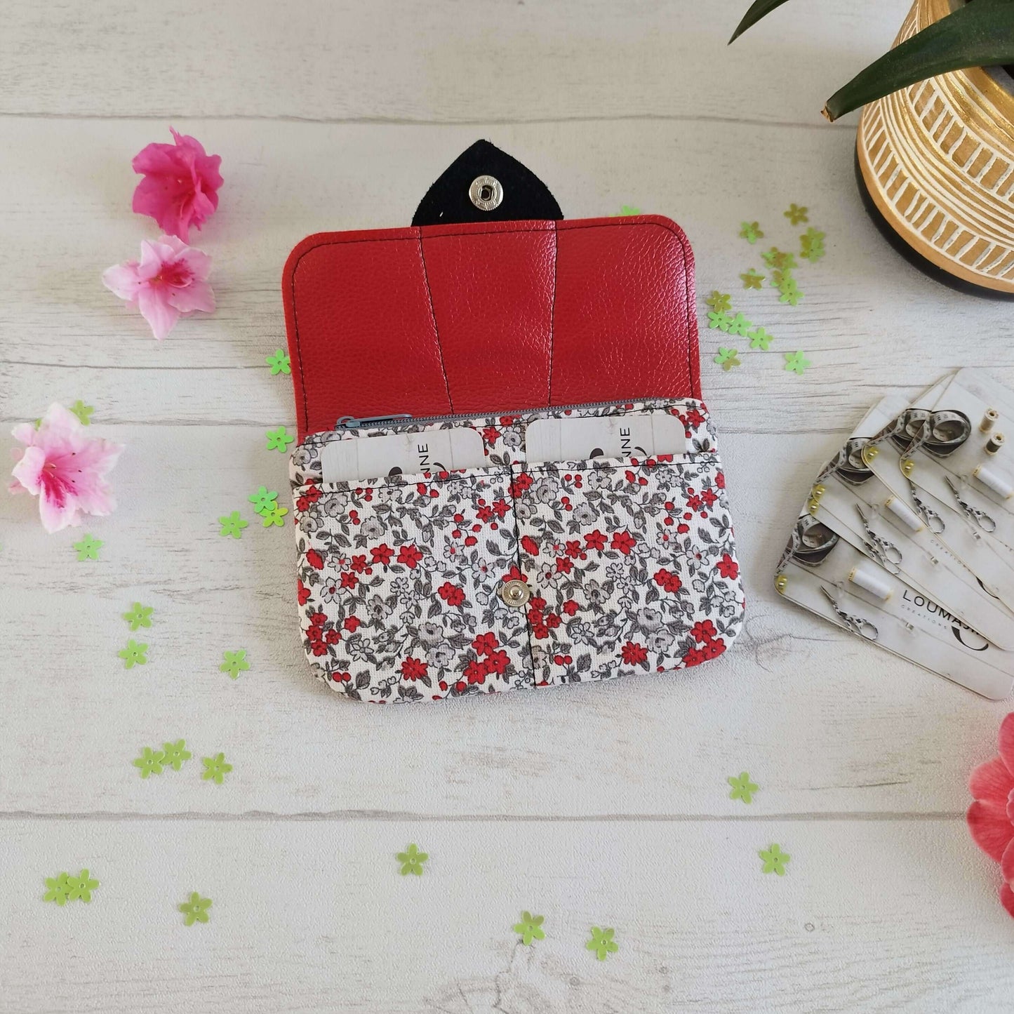 Porte-monnaie Laura avec design fleuri et rabat en simili cuir rouge, idéal pour cartes et monnaie.