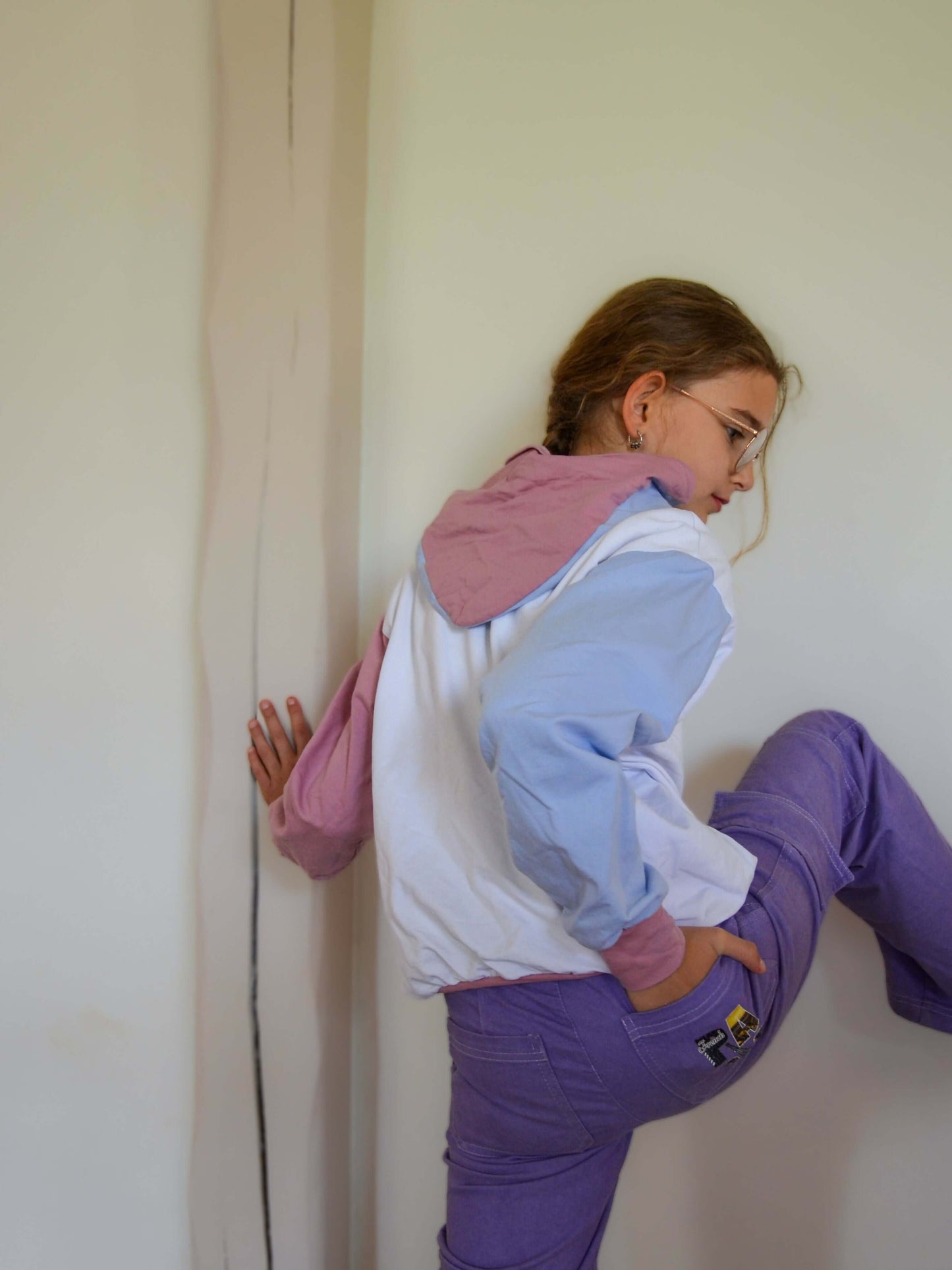 Jeune fille portant le Pull ANGEL avec manches chauve-souris, col capuche, disponible en patron de couture pdf à télécharger.