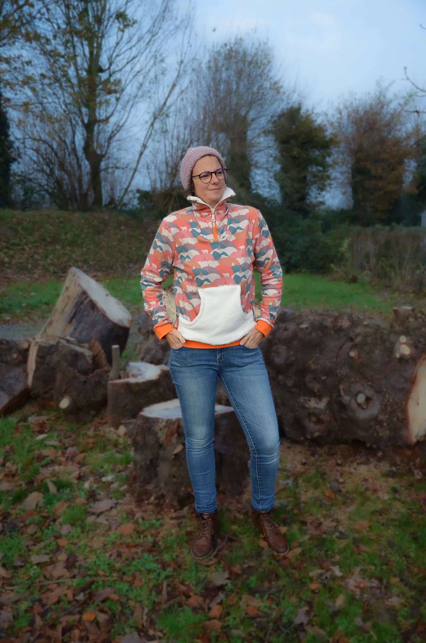 Femme portant Pull TRUCK du XXS au 6XL, patron de couture pdf à télécharger, devant des troncs d'arbres, automne.