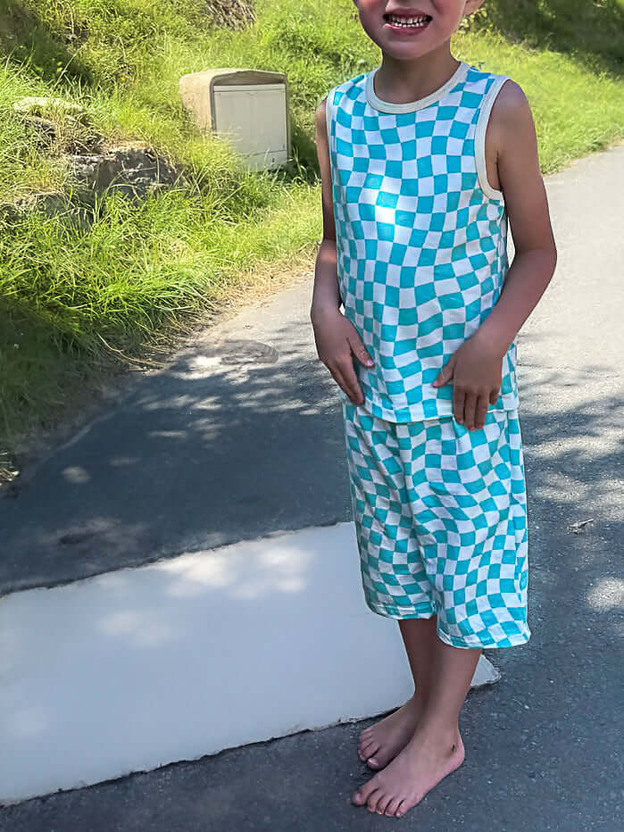 Enfant portant un Pyjama/Pyjamshort DIABOLO MENTHE, patron de couture pdf à télécharger, débardeur à carreaux bleu et blanc.