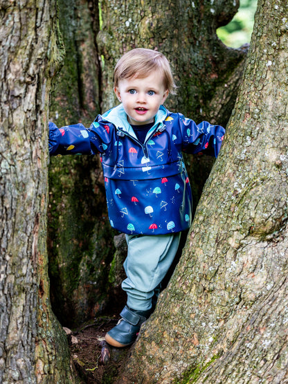 Enfant portant le QUETSCHE - Le coupe-vent à poche ventrale dans la forêt, patron de couture pdf à télécharger.