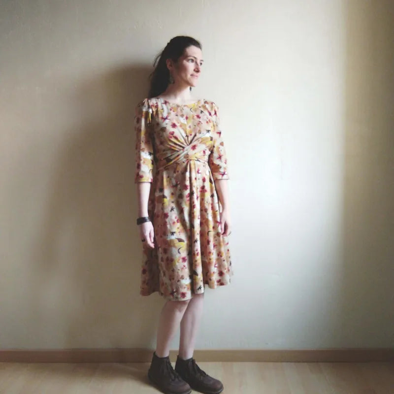 Femme portant la Robe "Azureen" du 32 au 60, patron de couture pdf à télécharger, manches ¾, impression florale, chaussures bottine.