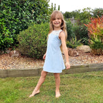 Fille portant la Robe / Blouse Gaby - Patron couture enfant du 2 au 14 ans, patron de couture pdf à télécharger, jardin en arrière-plan.