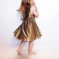Enfant portant la Robe Cylia Enfants dorée, patron de couture pdf à télécharger, idéale pour les 2 à 12 ans, confortable et stylée.