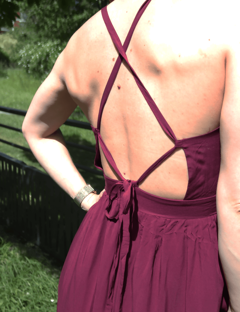 Détail du dos de la robe Delhi en bordeaux, avec des bretelles croisées et un élégant nœud. Parfait pour la couture.