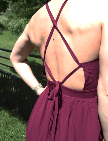 Détail du dos de la robe Delhi en bordeaux, avec des bretelles croisées et un élégant nœud. Parfait pour la couture.