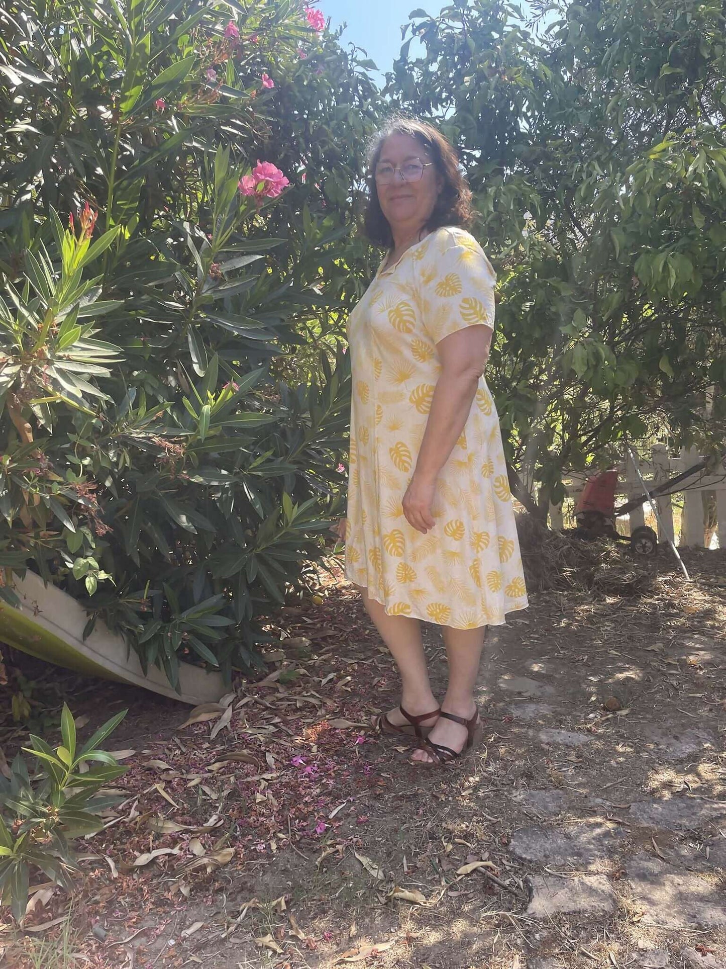 Robe Gaby Femmes portée dans un jardin, design moderne en jaune et blanc, patron pdf à télécharger.