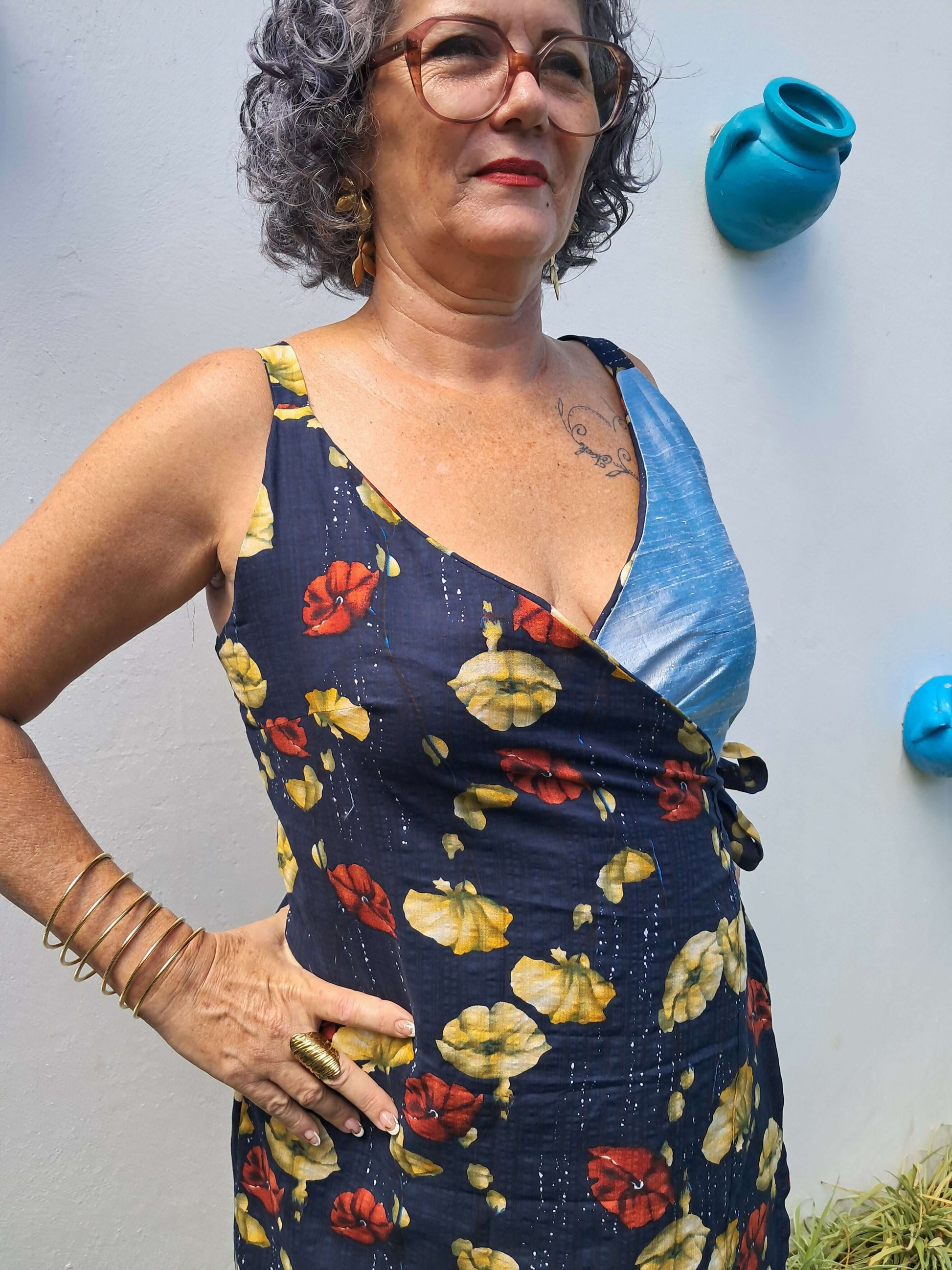 Femme portant une robe portefeuille à fleurs, décolleté innovant et style féminin décontracté en extérieur.